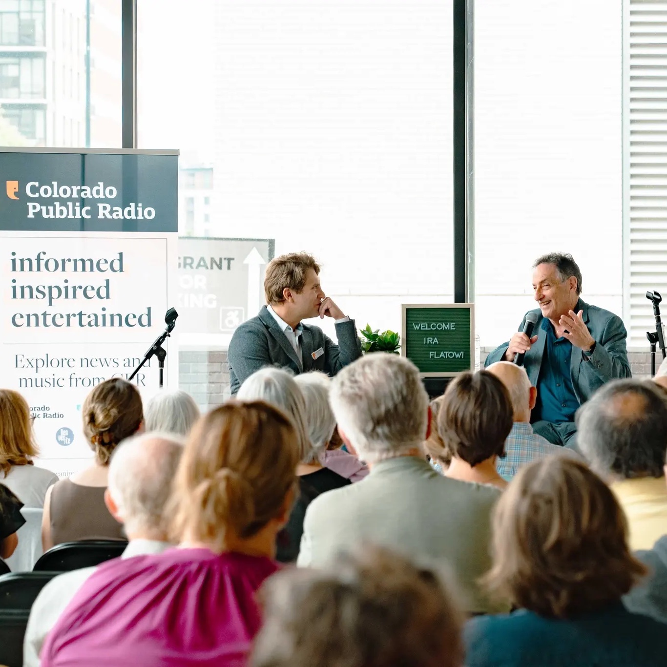 Ira Flatow and a person speaking in front of a crowd